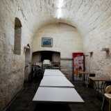 ...all�interno della quale, in fondo a una lunga tavolata e dietro a un �castello� di sedie...